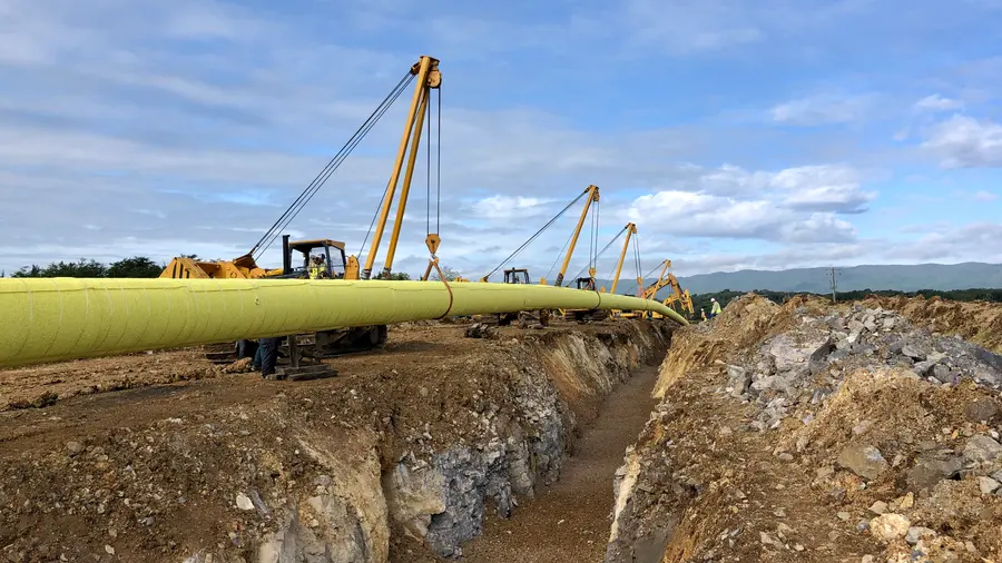Sidebooms lowering a large-diameter pipeline into the trench along a cross-country right-of-way