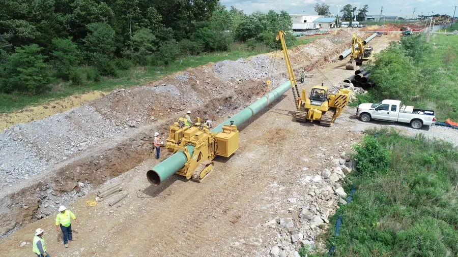Aerial view of a welded pipeline being lowered into the trench